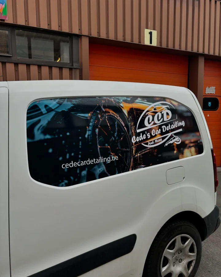 Bedrukte zijruit van een witte bestelwagen voor een detailingbedrijf