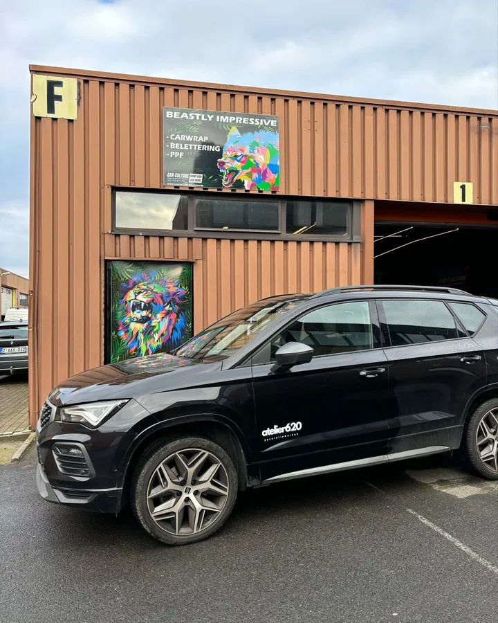 Subtiele witte bedrijfsbelettering op een zwarte SUV
